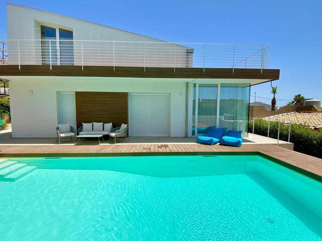 une maison avec une piscine devant une maison dans l'établissement Villa Lucia - Piscina Privata Riscaldata, à Marina di Ragusa