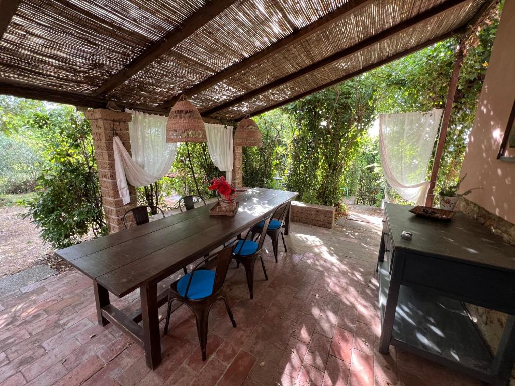 une table et des chaises en bois sur une terrasse dans l'établissement La casa nel bosco, à Lari
