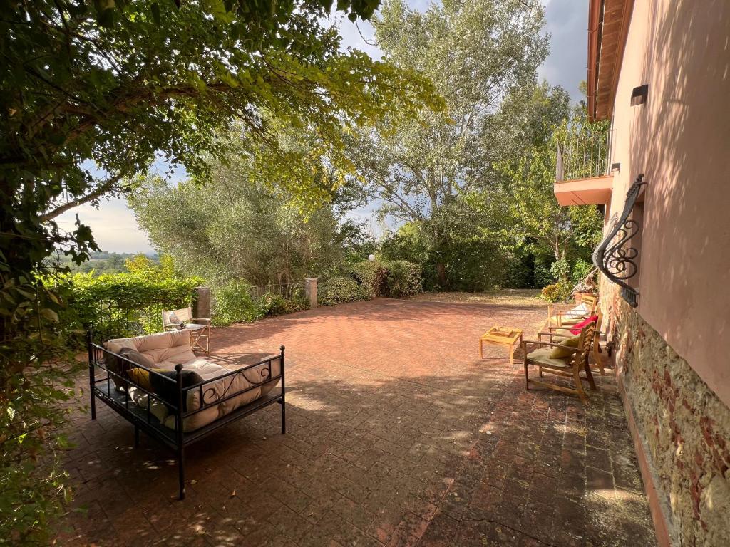un patio avec un canapé et des chaises sur une cour en briques dans l'établissement La casa nel bosco, à Lari
