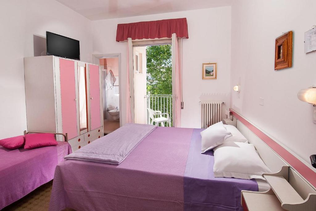 une chambre avec un lit violet et une fenêtre dans l'établissement Hotel Cheri, à Rimini