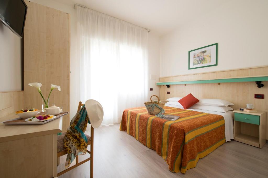 une chambre d'hôtel avec un lit et une table dans l'établissement Hotel Pillon, à Bibione