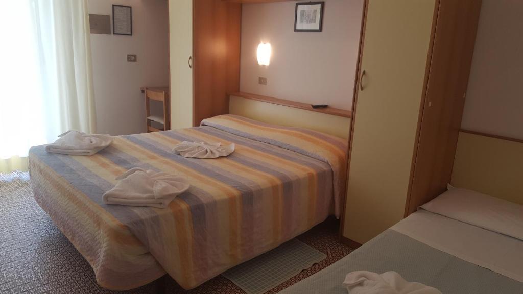 une chambre d'hôtel avec un lit avec des serviettes dessus dans l'établissement Hotel Conti, à Rimini