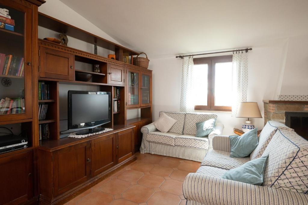 un salon avec un canapé et une télévision dans l'établissement Villa immersed in green Isola dei Cavalli, à Quadroni