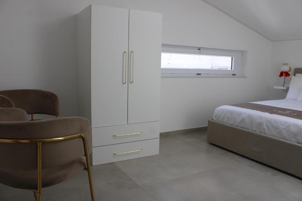 une chambre avec un lit, une commode et une chaise dans l'établissement Cridima Luxury - Villa Dea, à Santa Maria La Carità