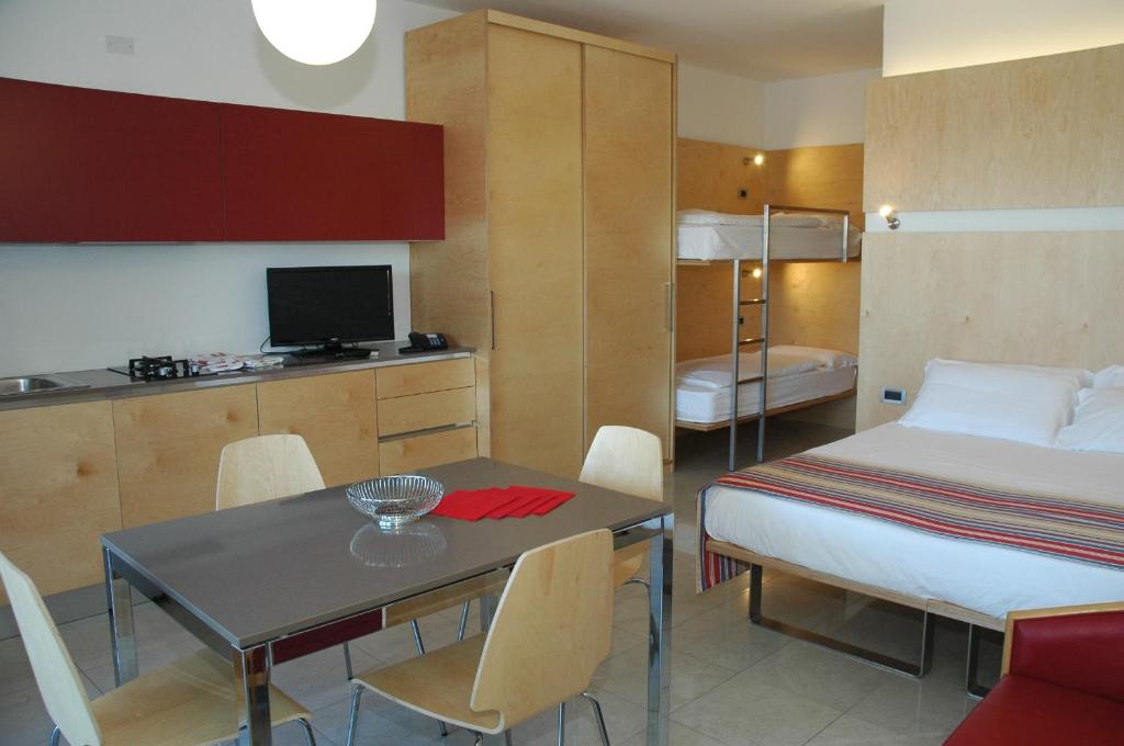 une chambre avec un lit et une table et une cuisine dans l'établissement Aparthotel Albatros, à Lignano Sabbiadoro 23 autres photos