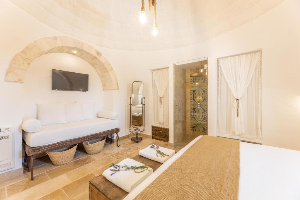 une chambre avec un lit et une télévision sur un mur dans l'établissement Villa Trulli del Gelso, à Carovigno