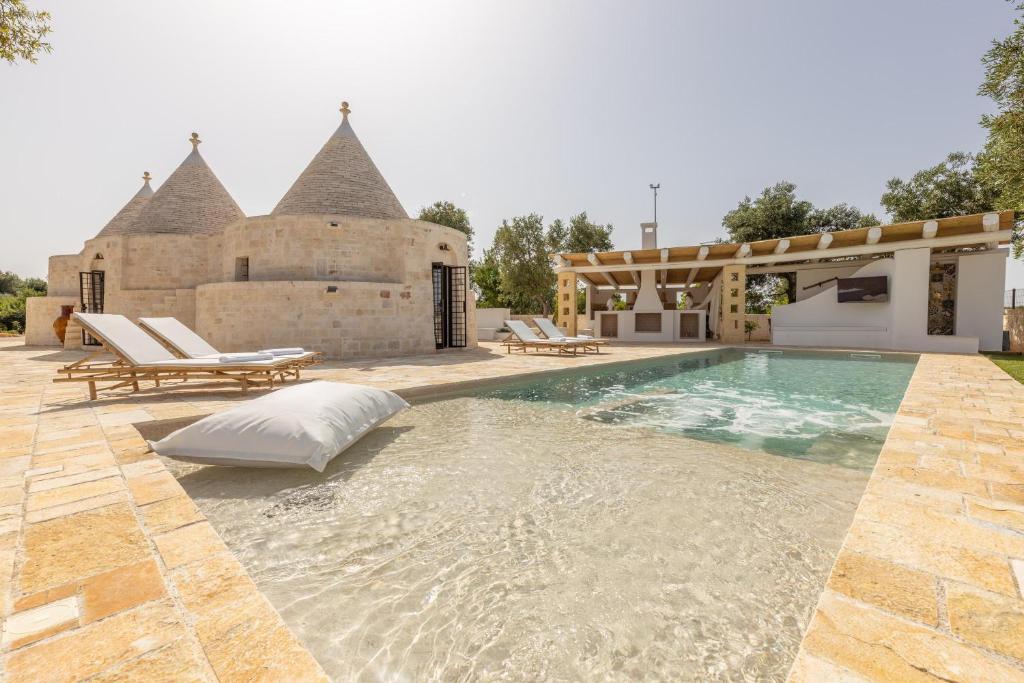 une piscine devant une maison dans l'établissement Villa Trulli del Gelso, à Carovigno