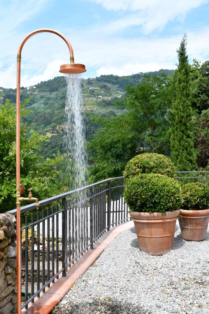 une fontaine à eau sur un balcon avec deux pots dans l'établissement Villa Mia Lucca - Modern Comfort in the Tuscan Hills, à Lucques 47 autres photos
