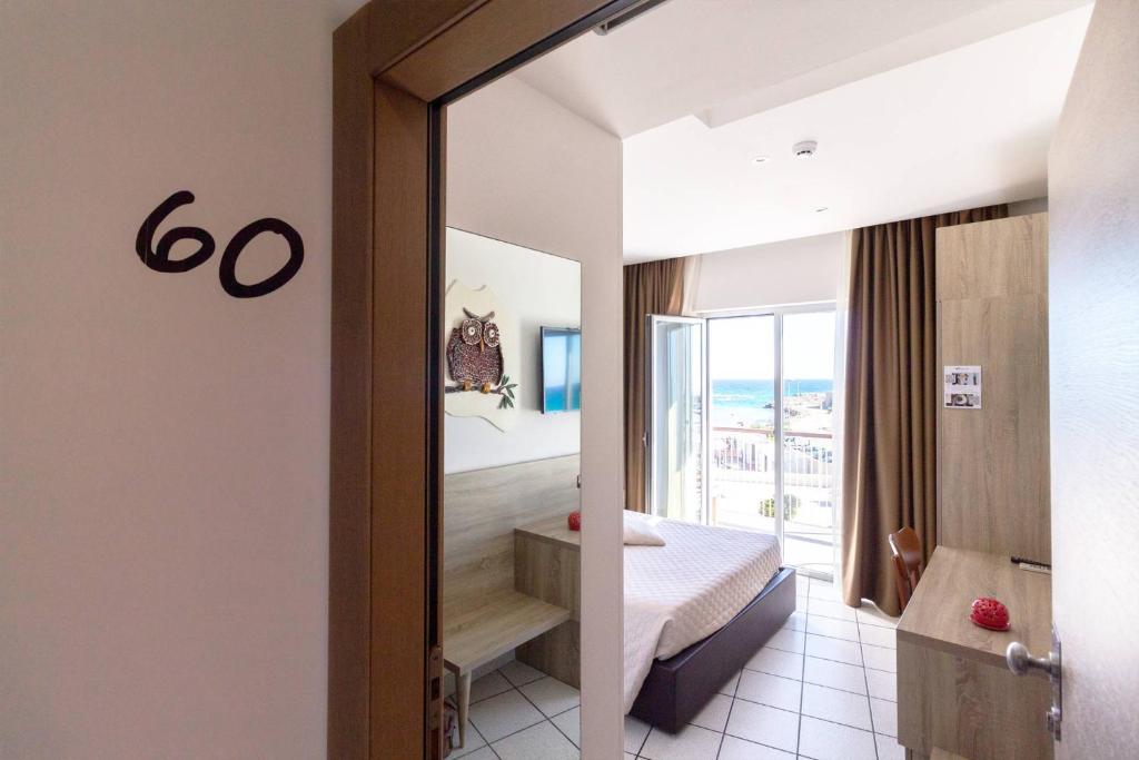 une chambre avec un lit et une vue sur une salle de bains dans l'établissement Hotel Da Romano, à San Foca