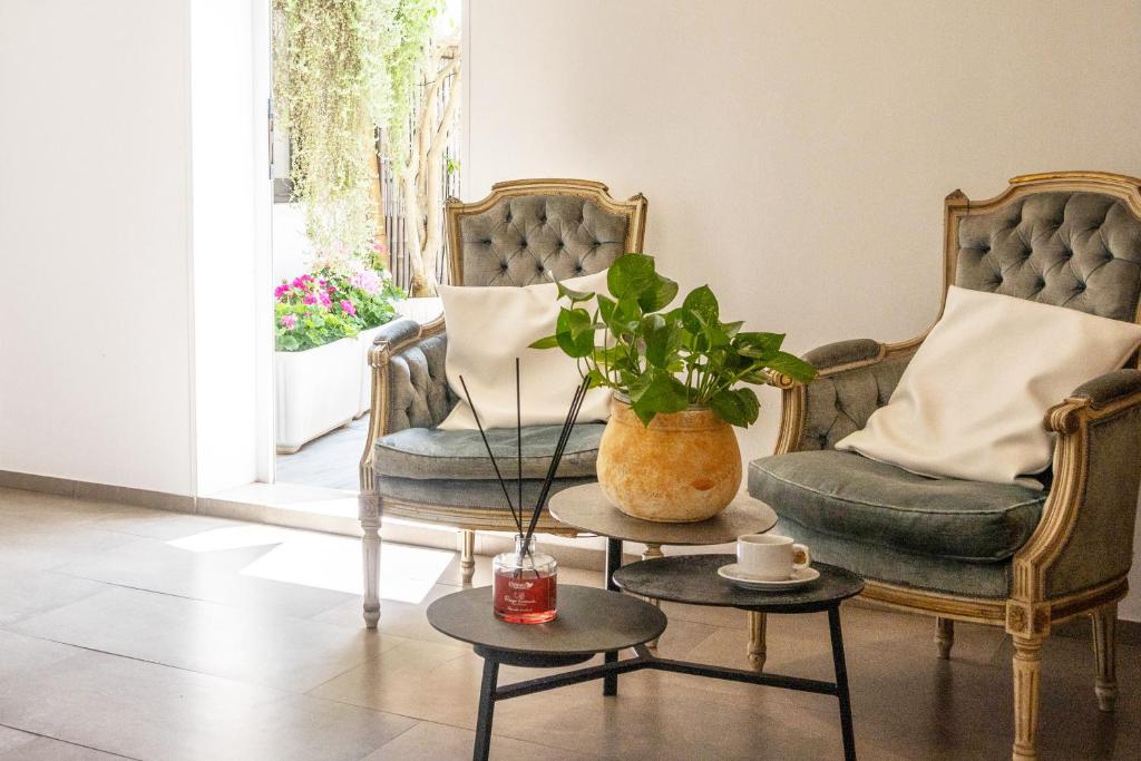 - un salon avec deux chaises et une table avec une plante dans l'établissement Hotel Da Romano, à San Foca