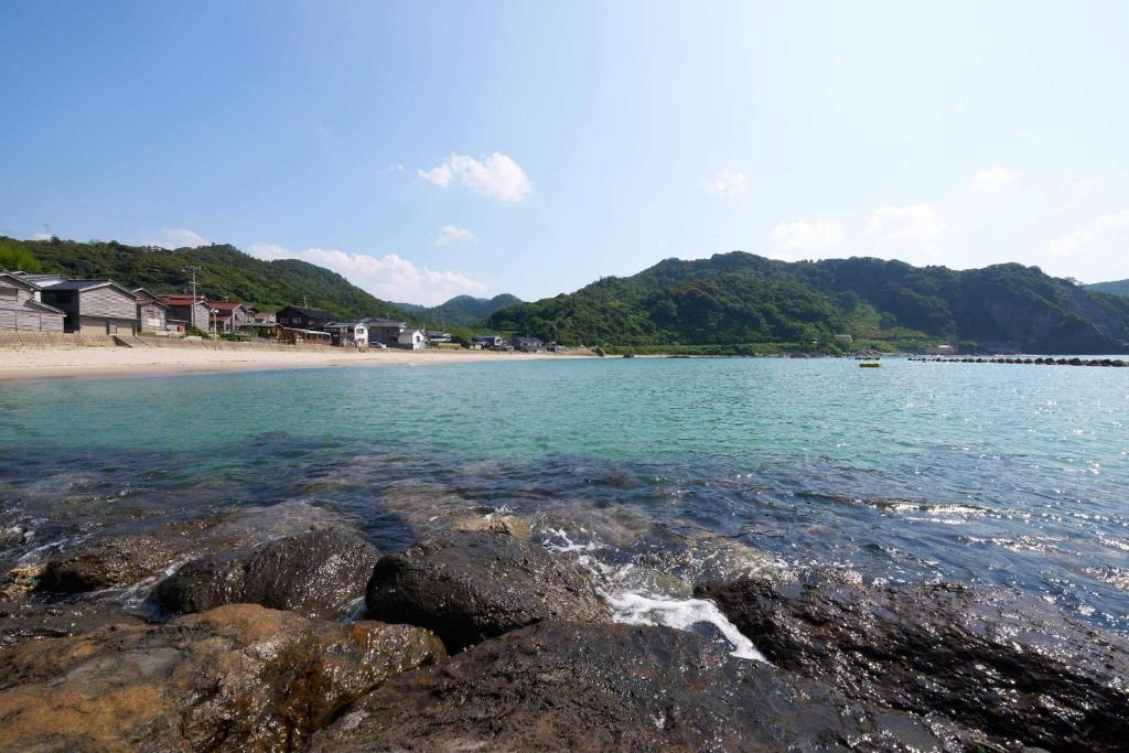 - une vue sur une plage avec des rochers dans l'eau dans l'établissement Yodoya, à Toyooka