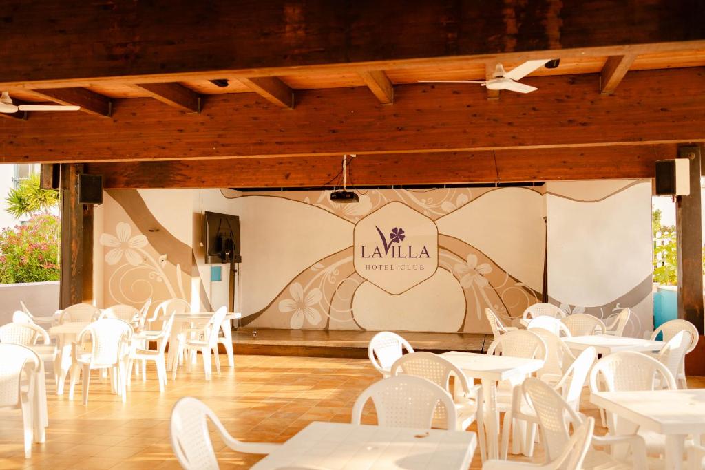 un restaurant avec des tables blanches et des chaises blanches dans l'établissement Hotel Club La Villa, à Martinsicuro 120 autres photos