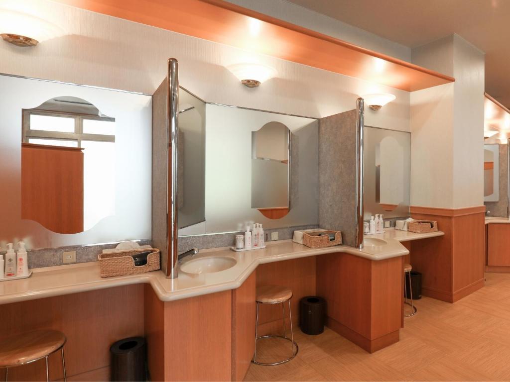 une salle de bain avec deux lavabos et deux miroirs dans l'établissement Ikoi no mura Notohanto, à Shika