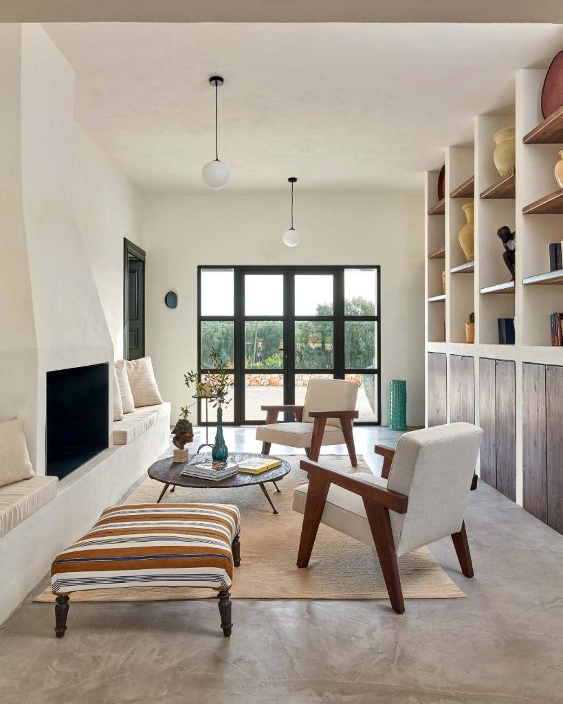 Elle comprend un salon doté d'un mobilier blanc et d'une cheminée. dans l'établissement Casa Musa, à Ostuni