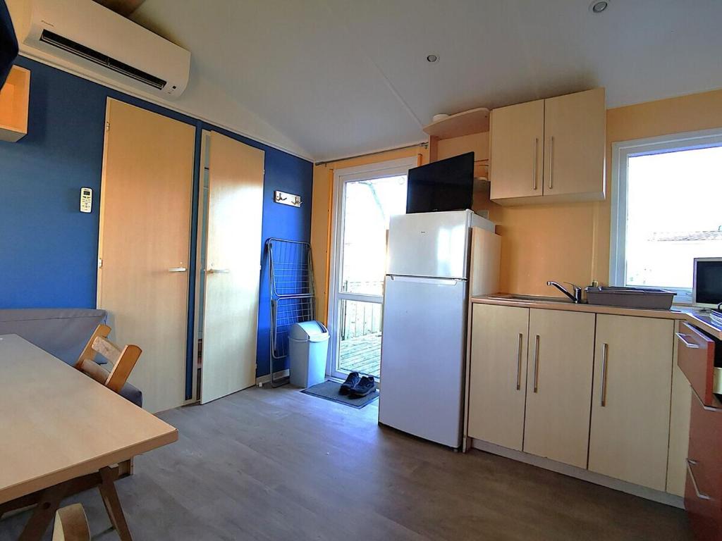 - une cuisine avec un réfrigérateur et une table dans la chambre dans l'établissement MH First 6pers 30min PuyduFou HellFest, à La Boissière-de-Montaigu