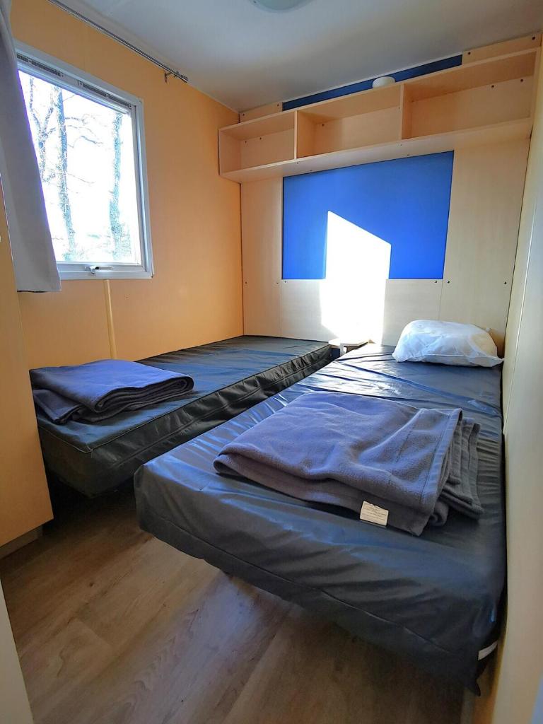 - 2 lits dans une chambre avec une lampe dans l'établissement MH First 6pers 30min PuyduFou HellFest, à La Boissière-de-Montaigu 16 autres photos