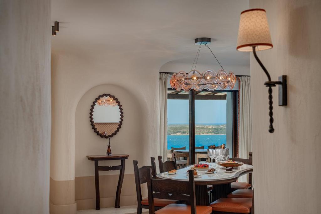 une salle à manger avec une table et des chaises et une fenêtre dans l'établissement Hotel Pitrizza, Costa Smeralda, à Porto Cervo