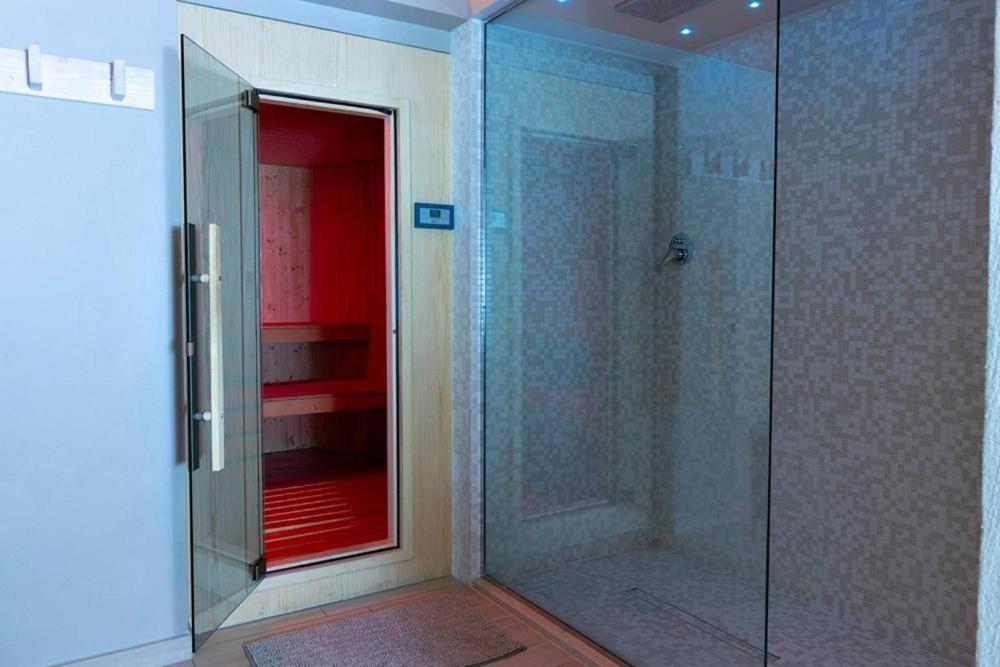 une douche avec une porte vitrée dans une salle de bain dans l'établissement Hotel Fiamma & SPA Cesenatico, à Cesenatico