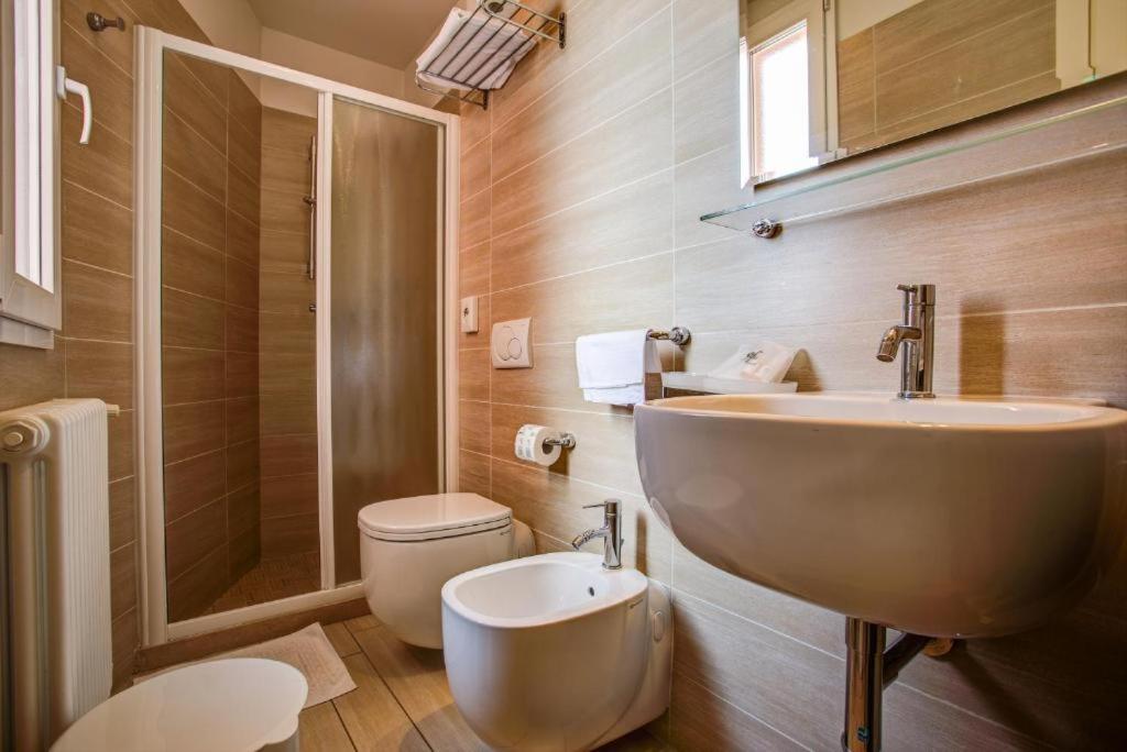 une salle de bain avec un lavabo et des toilettes dans l'établissement Hotel Fiamma & SPA Cesenatico, à Cesenatico 93 autres photos