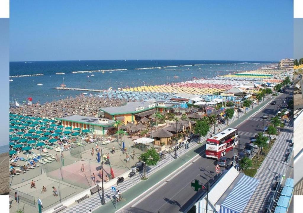 une plage avec une foule de gens et l'océan dans l'établissement Hotel Fiamma & SPA Cesenatico, à Cesenatico