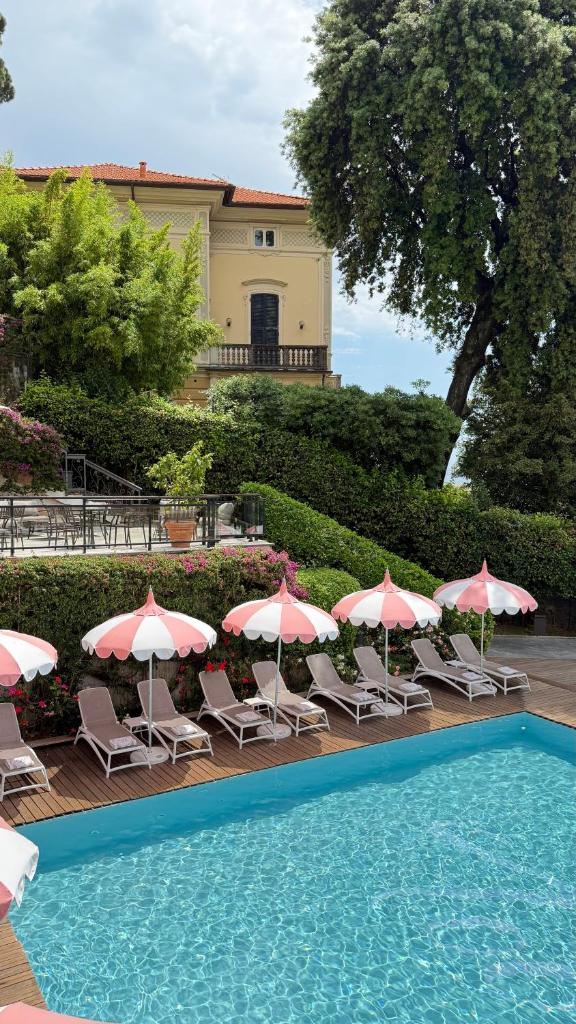 un groupe de chaises et de parasols à côté d'une piscine dans l'établissement Grand Hotel Bristol Spa Resort, by R Collection Hotels, à Rapallo