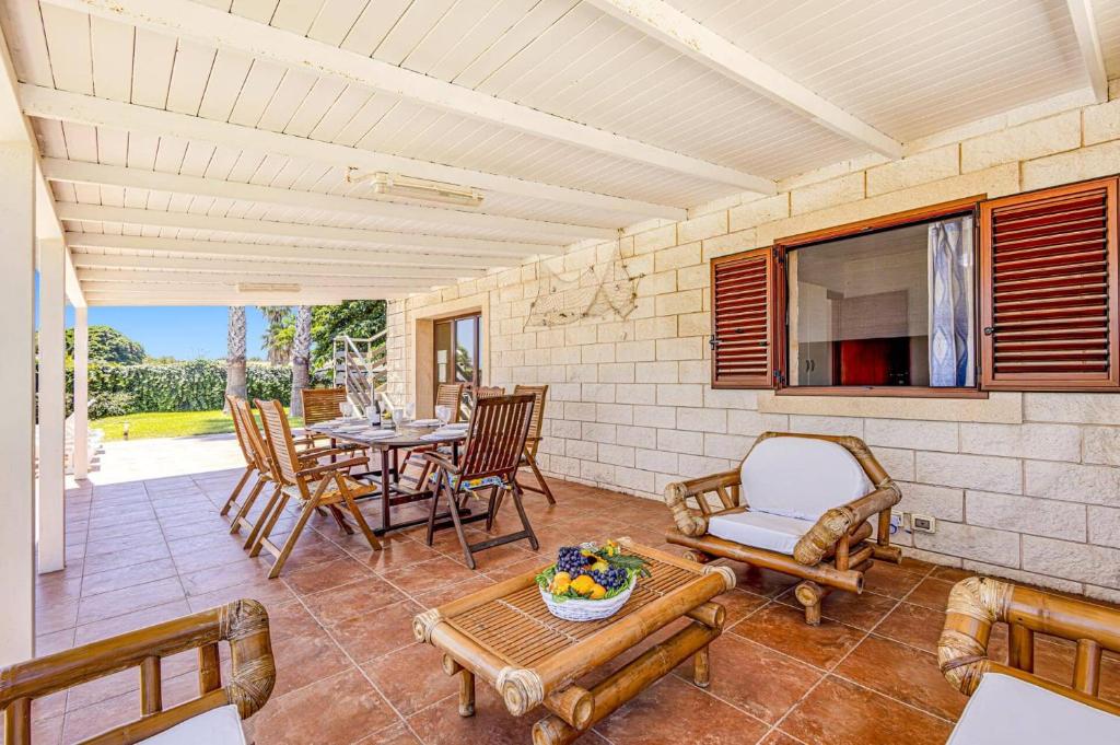 d'une terrasse avec une table, des chaises et une table. dans l'établissement Villa Garofani by Villa Plus, à Punta Secca