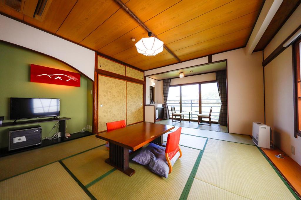 un salon avec une table et une télévision dans l'établissement Ryokan Kiritani Hakoneso, à Hakone