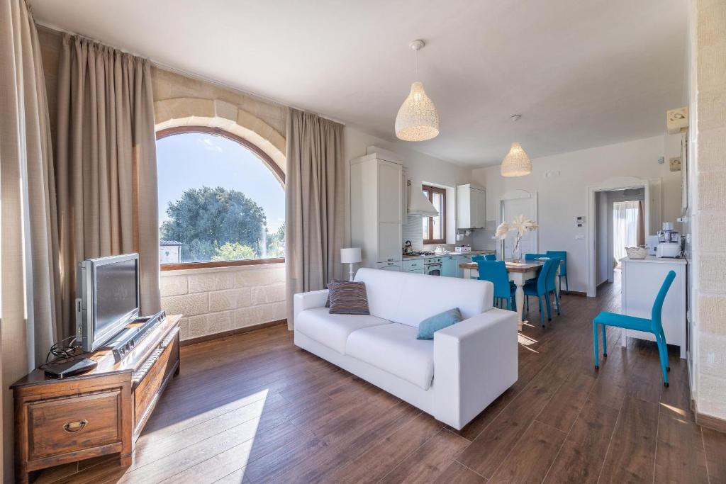 un salon avec un canapé blanc et une télévision dans l'établissement Villa Icaria, à Carovigno