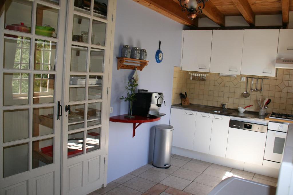 une cuisine avec des armoires blanches et un comptoir dans l'établissement Gîte Fénil Dans Le Lot Avec Vue Panoramique, à Lacam-dʼOurcet