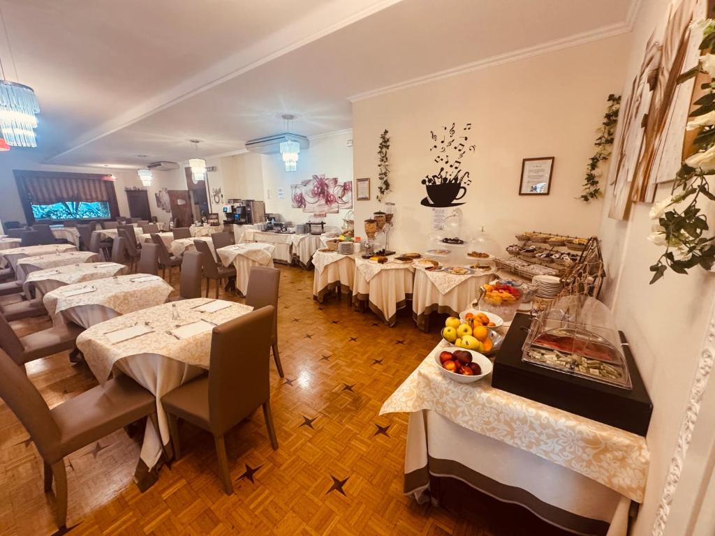 un restaurant avec des tables et des chaises et un buffet dans l'établissement Hotel Principe, à Sanremo