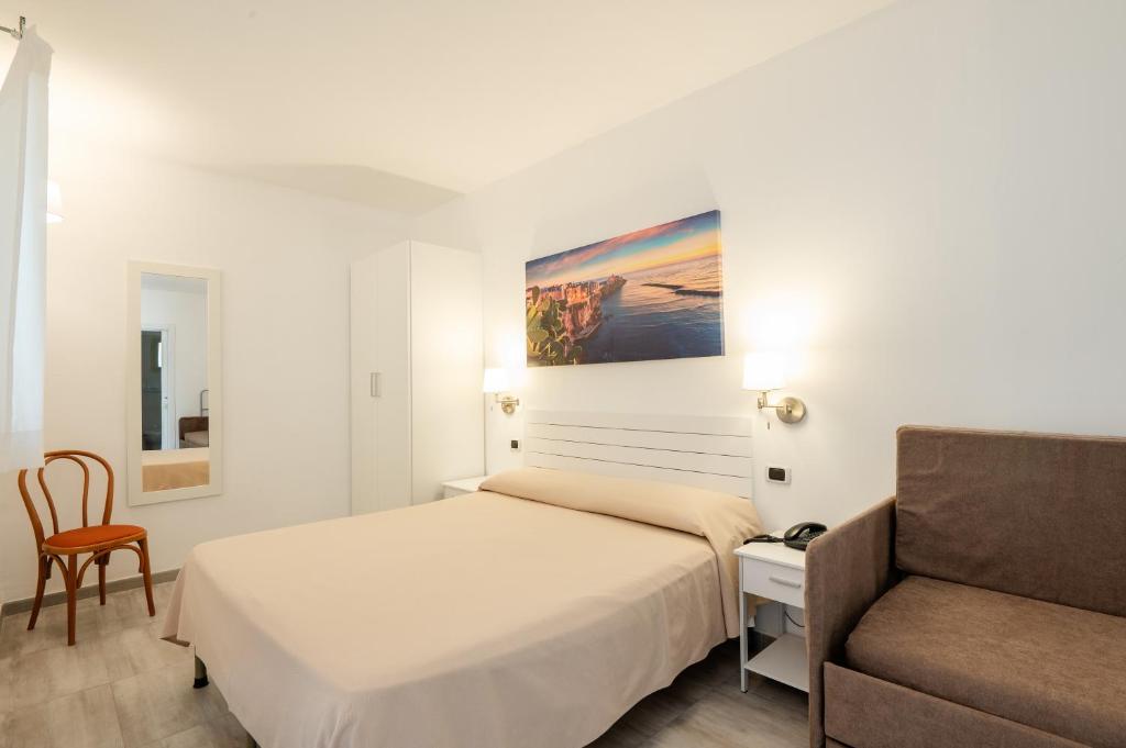 une chambre avec un lit, une chaise et un canapé dans l'établissement Garden Hotel Ripa, à Vieste 97 autres photos