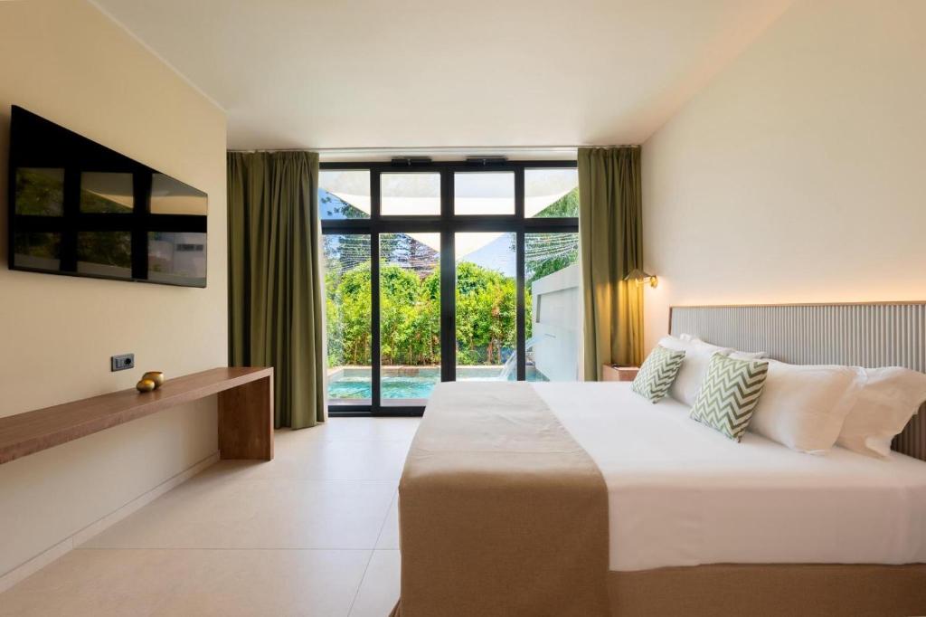 une chambre avec un grand lit et une grande fenêtre dans l'établissement ananea Tropea Yachting Resort, à Tropea