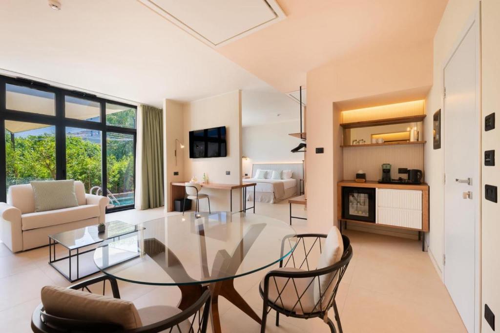 un salon avec une table en verre et des chaises dans l'établissement ananea Tropea Yachting Resort, à Tropea