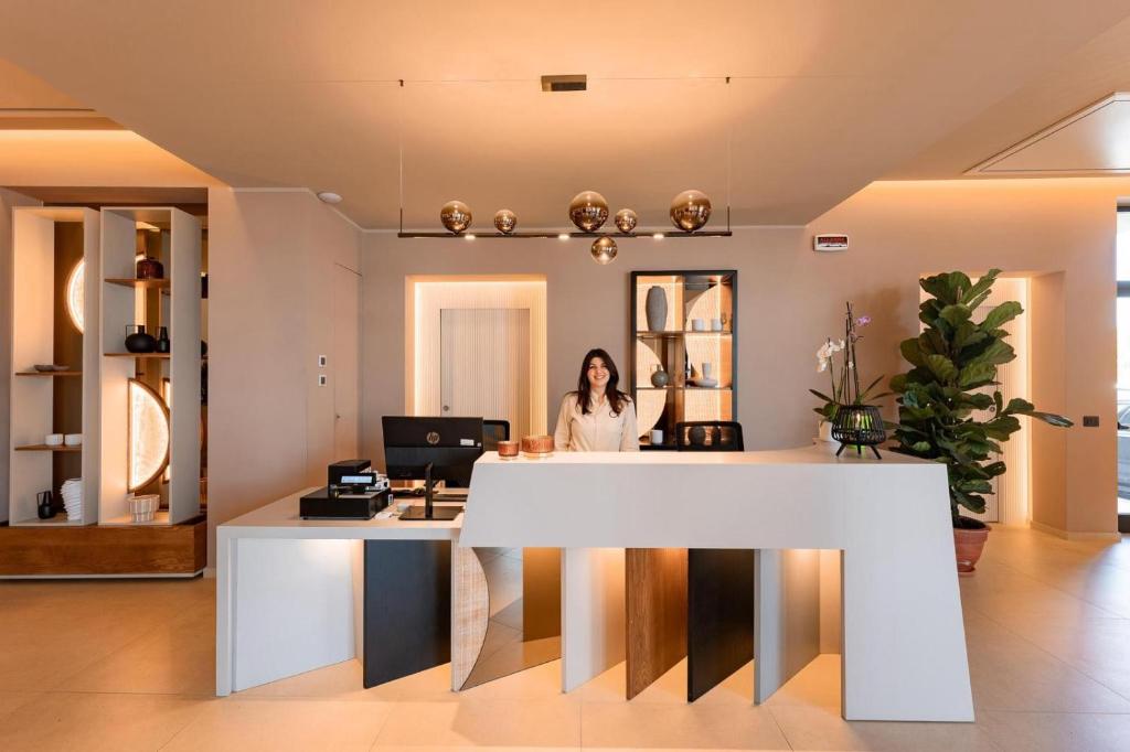 une femme assise à un bureau dans un bureau dans l'établissement ananea Tropea Yachting Resort, à Tropea 144 autres photos
