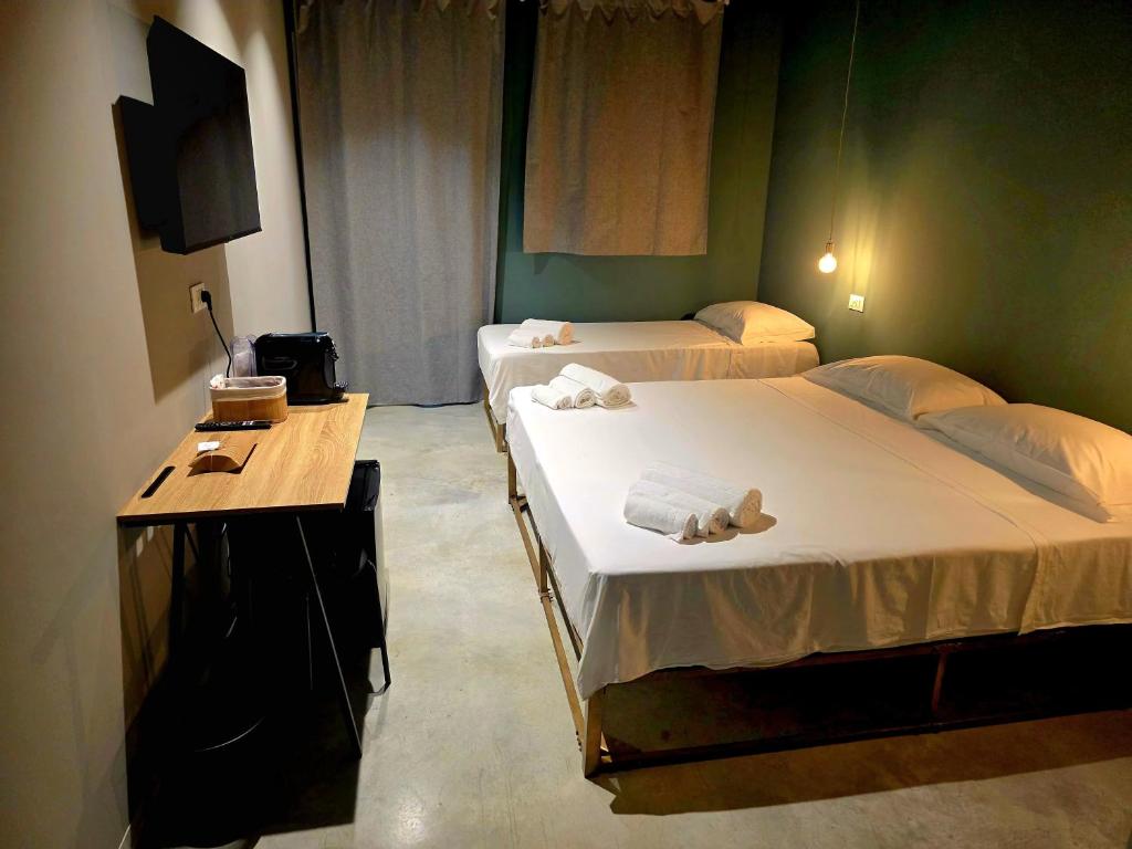 deux lits dans une chambre aux murs verts dans l'établissement Sottocoperta, à Roseto degli Abruzzi