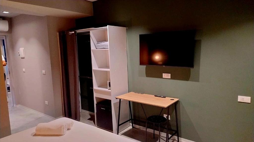 Cette chambre comprend un lit, un bureau et une télévision. dans l'établissement Sottocoperta, à Roseto degli Abruzzi