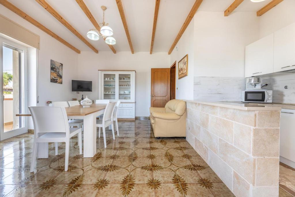 une cuisine et une salle à manger avec une table et des chaises dans l'établissement Villa Ermelinda, à Marina di Mancaversa