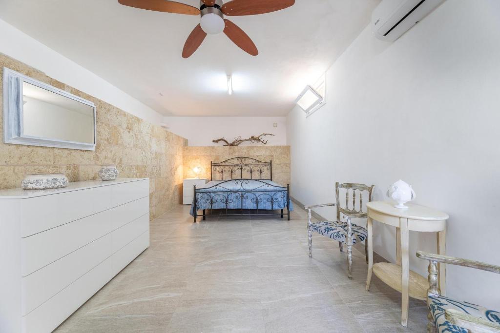 une chambre avec un lit et un ventilateur de plafond dans l'établissement Villa Ermelinda, à Marina di Mancaversa