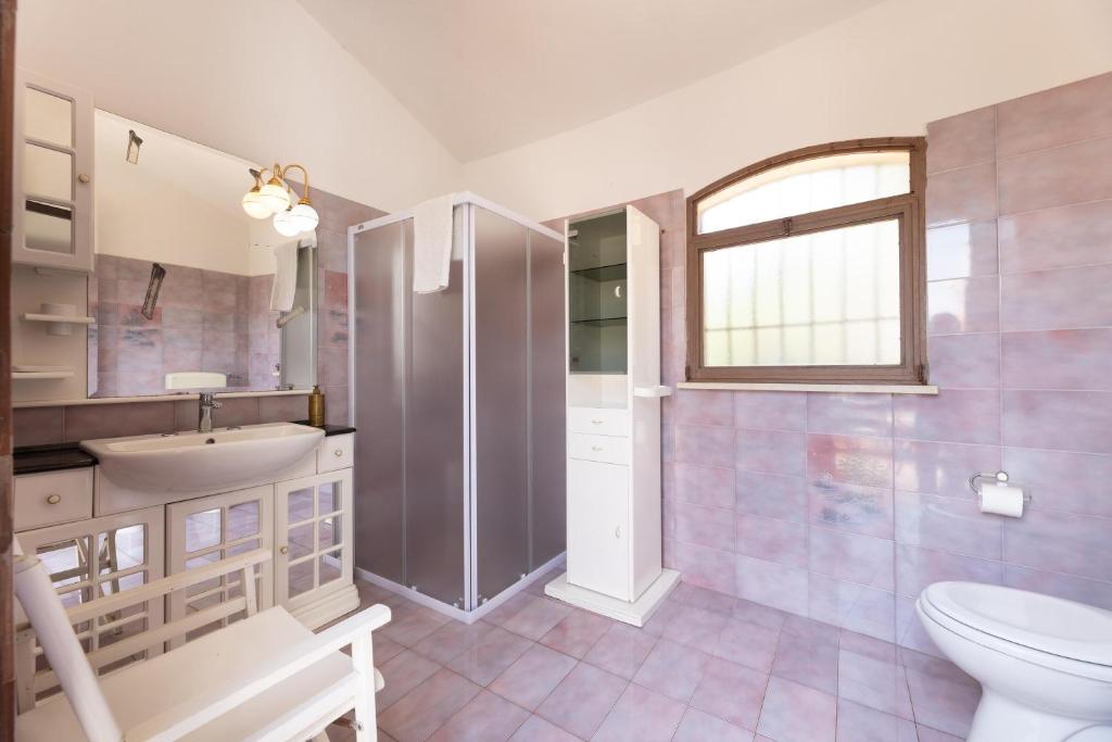 La salle de bains est pourvue d'un lavabo, de toilettes et d'une fenêtre. dans l'établissement Villa Ermelinda, à Marina di Mancaversa
