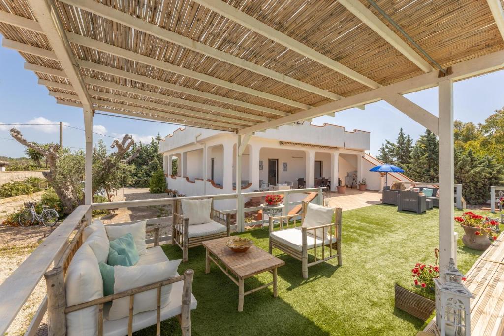 un patio extérieur avec une pergola en bois dans l'établissement Villa Ermelinda, à Marina di Mancaversa