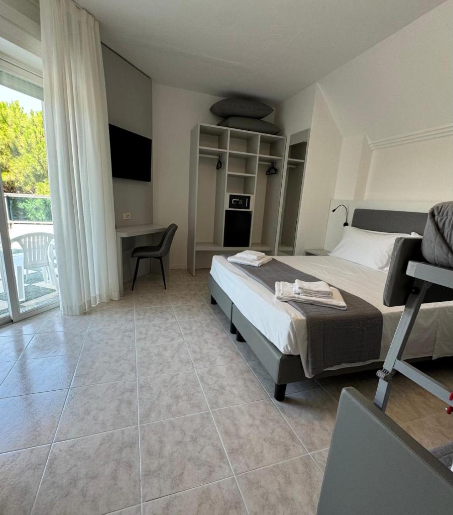 une chambre avec un lit et un bureau avec une chaise dans l'établissement Hotel DOLCEVITA Park & Beach included, à Lido di Jesolo