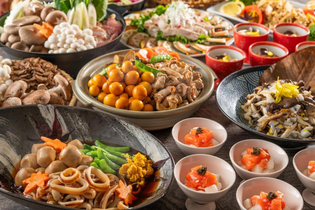une table avec de nombreux bols de différents types de denrées alimentaires dans l'établissement KAMENOI HOTEL Tazawako, à Senboku