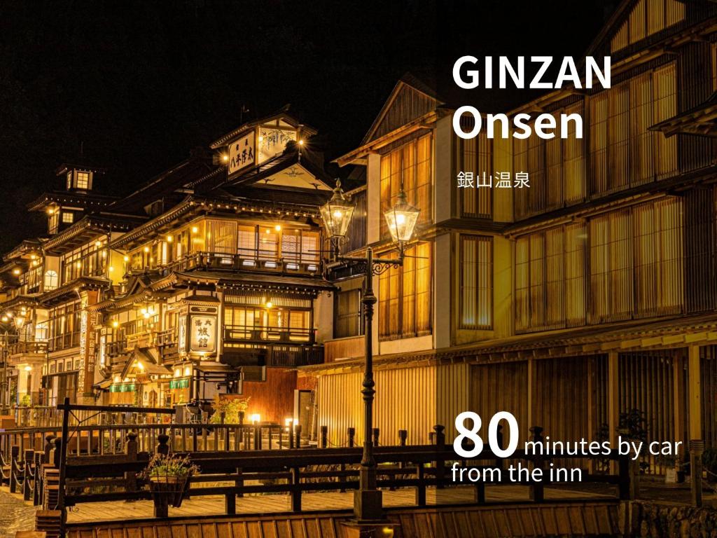 un groupe de bâtiments la nuit avec les mots gimian queen dans l'établissement Senkeien Tsukioka Hotel, à Kaminoyama