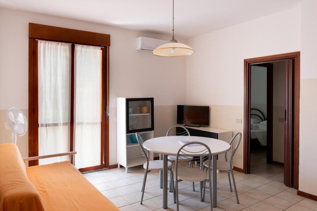 un salon avec une table et des chaises dans l'établissement Aurora Residence, à Lido Adriano