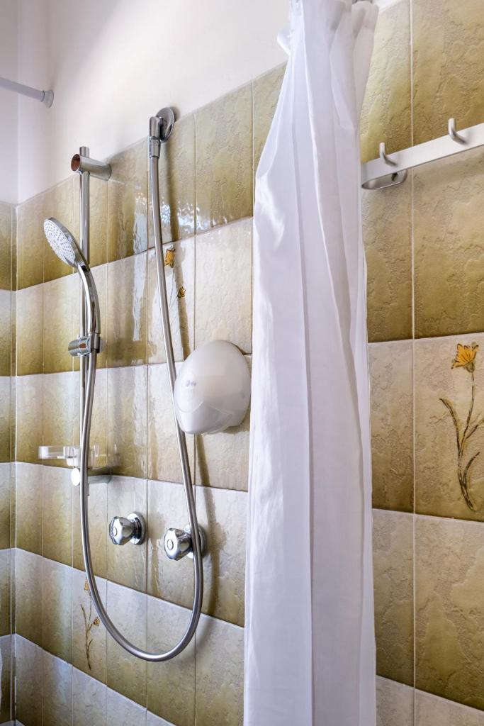 une douche avec un rideau de douche dans une salle de bain dans l'établissement Aurora Residence, à Lido Adriano