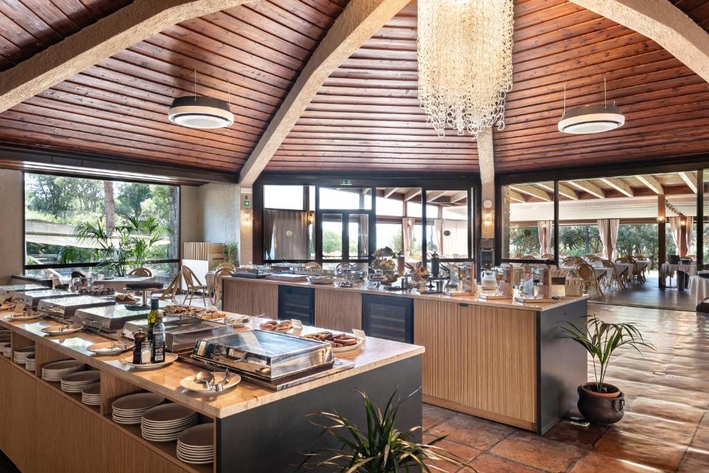 un restaurant avec une ligne de buffet dans un bâtiment dans l'établissement Roccamare Resort - Casa di Ponente, à Castiglione della Pescaia