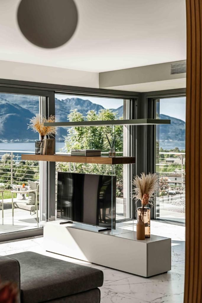 - un salon avec une cheminée et de grandes fenêtres dans l'établissement Villa Afrodite Lake Como - Luxury Italian Design, à Gravedona