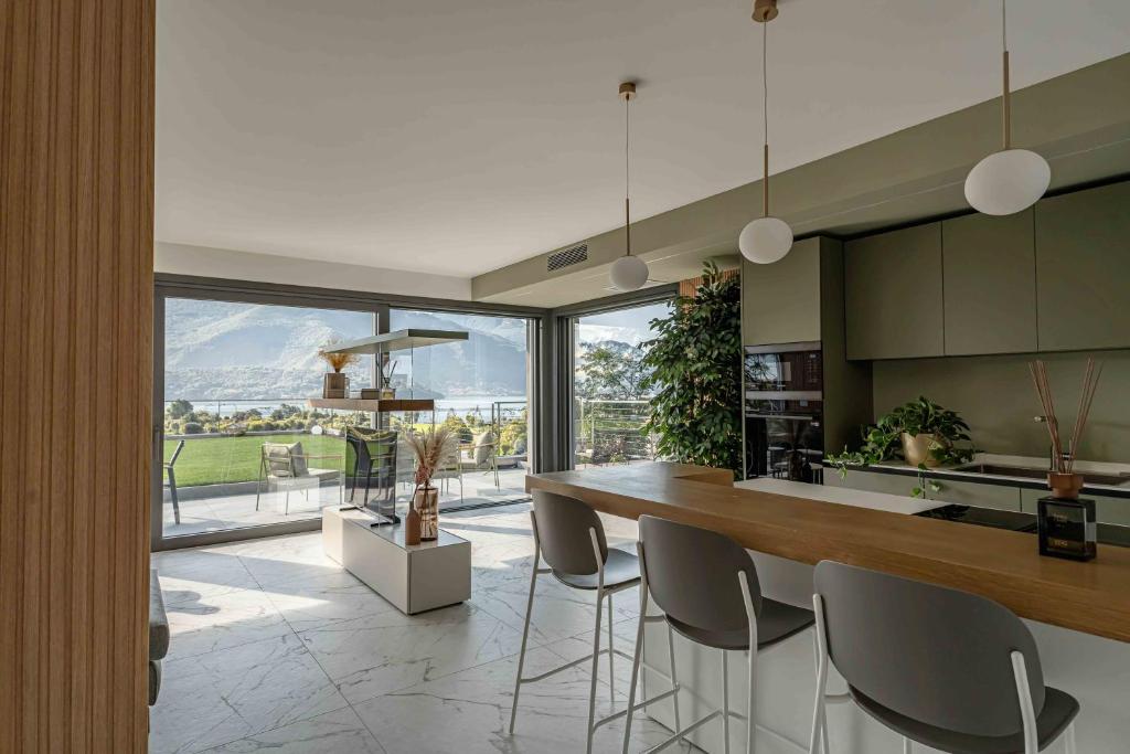 une cuisine avec une table et des chaises ainsi qu'une grande fenêtre dans l'établissement Villa Afrodite Lake Como - Luxury Italian Design, à Gravedona