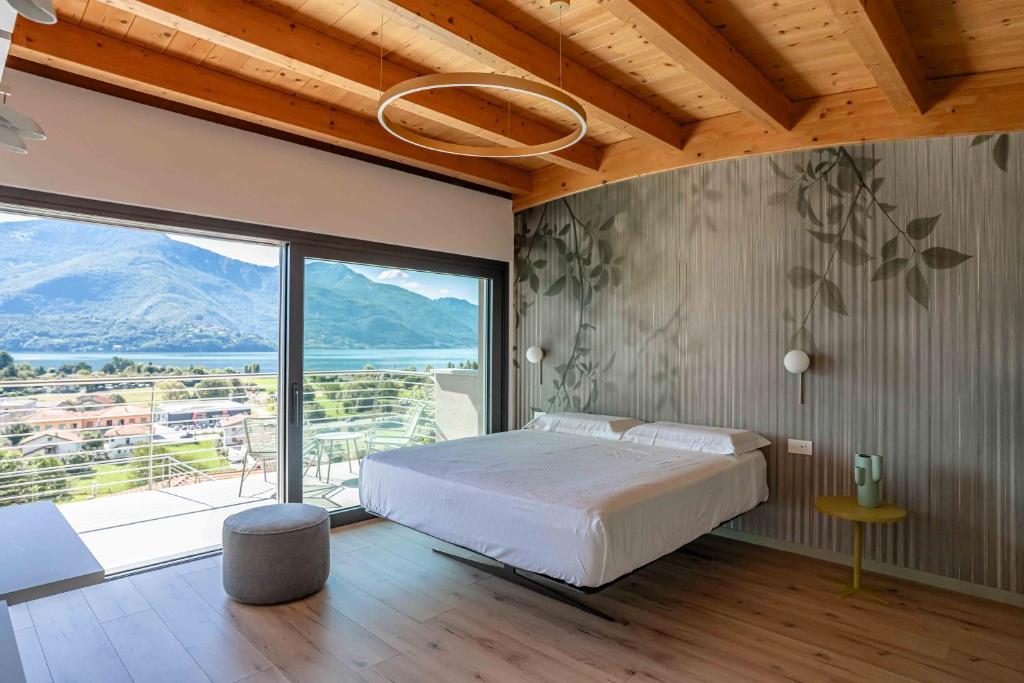 une chambre avec un lit et une grande fenêtre dans l'établissement Villa Afrodite Lake Como - Luxury Italian Design, à Gravedona