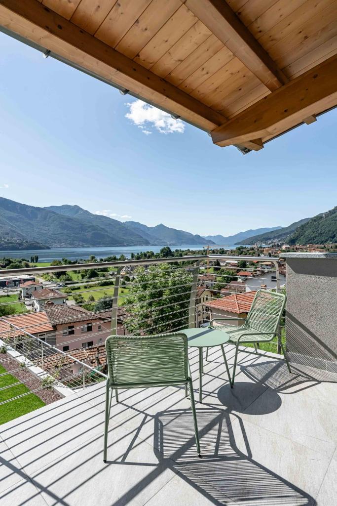 un patio avec deux chaises et une table sur une terrasse dans l'établissement Villa Afrodite Lake Como - Luxury Italian Design, à Gravedona